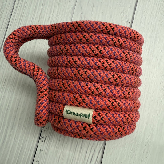 A coiled rope with a label that reads "Cactus Pine" is placed on a white wooden surface.