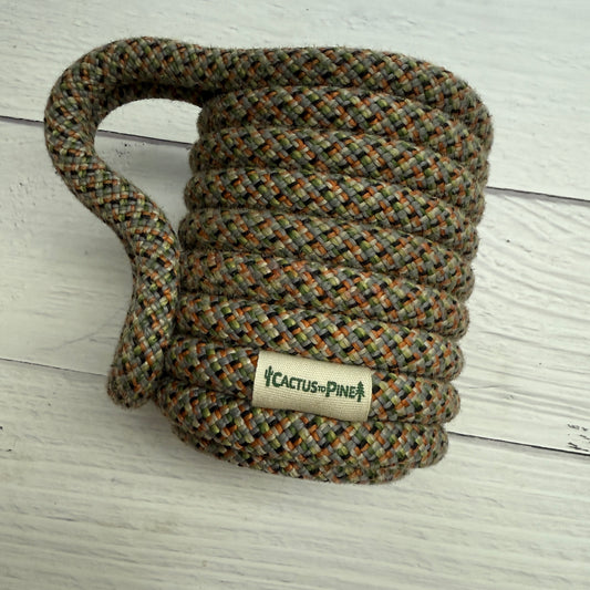A coiled rope with a label that reads "Cactus Pine" on it, placed on a white wooden surface.